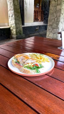 Tahta bir masada etli ve sebzeli bir tabak lezzetli patates kızartmasının yüksek açılı görüntüsü.