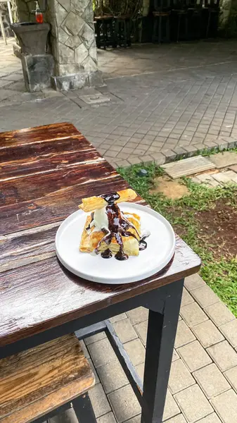 Dondurmalı kek ve ahşap masada çikolata sosu.