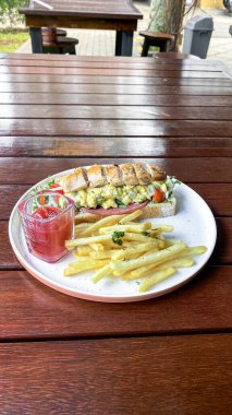 Tavuk, patates kızartması ve taze sebzeli lezzetli ve sağlıklı bir sandviç..