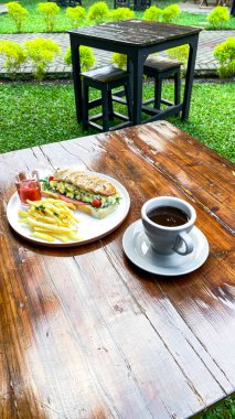 Bahçedeki masada bir fincan çay, kahve ve kahve..