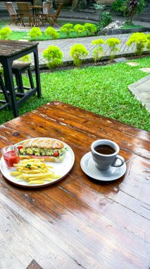 Bir fincan kahve ve ahşap masada bir pasta..