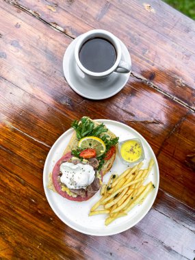 Tahta bir masada kahve ve kızarmış yumurta ile lezzetli ve sağlıklı bir kahvaltı.