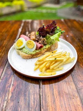 Bir tabak et, peynir ve marullu sandviç..