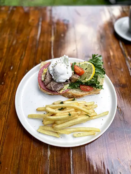 Tavada kızarmış yumurta ve patates kızartması ile hamburger.