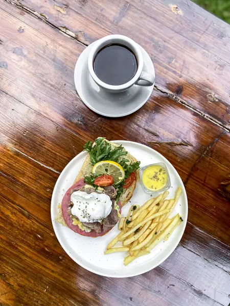 Tahta bir masada kahve ve kızarmış yumurta ile lezzetli ve sağlıklı bir kahvaltı.