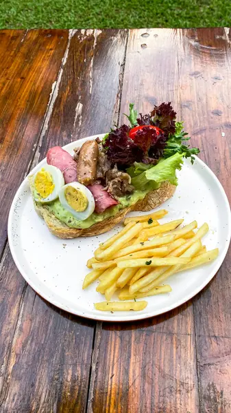 Kızarmış et, sebze ve soslu sandviç.