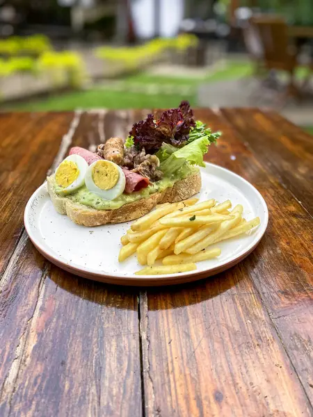 Tahta tabakta etli, sebzeli ve peynirli sandviç.