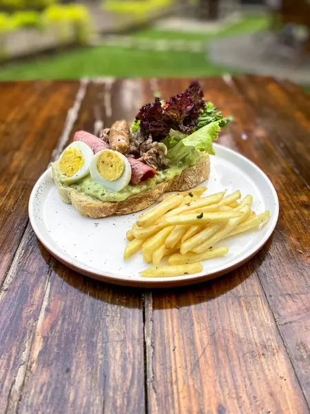 Tahta bir masada biftek ve sebzeli sandviç.