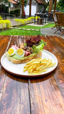 Tahtaya etli, marullu ve ketçaplı lezzetli bir sandviçin yakın çekimi.