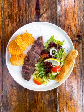 Beyaz tabakta kızarmış biftek.