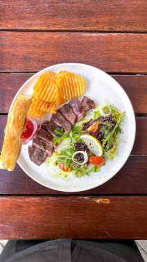 Tahta masada sebzeli ızgara biftek.