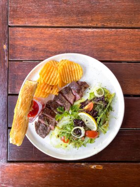 Kızarmış biftek, salata ve patates kızartması, üst manzara, fotokopi alanı..