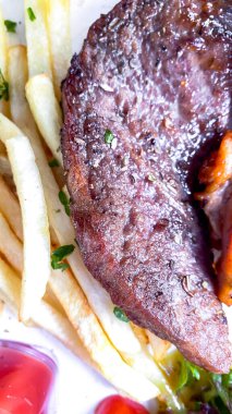 Beyaz tabakta ızgara biftek.