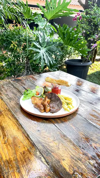 Sebzeli ızgara domuz pirzolası ve ahşap masada sos.