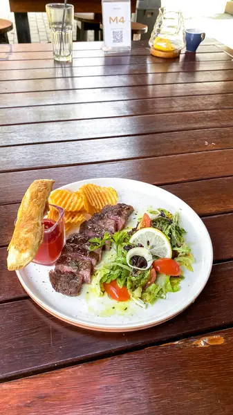 Masanın üzerinde bir tabak et ve sebzenin mutfak fotoğrafı.