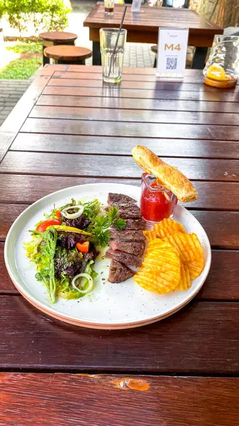 Sebzeli biftek ve tahta tabakta salata.