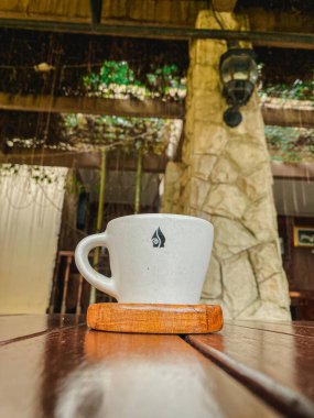 Kafedeki kahve fincanı ahşap bir masanın üstünde.