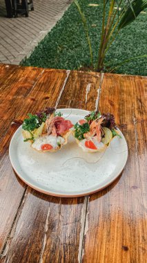 Sebzeli ve etli bir tabak sandviç.