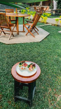 Masanın üzerinde ahşap bir sandalye olan bir tabağın yakın çekimi.