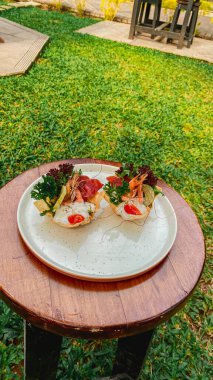 Ahşap bir masada ızgara tavuk ve sebze.