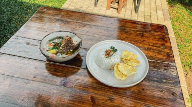 Kızarmış pilav, beyaz tabakta yumurta, ahşap kaplama, üst manzara.