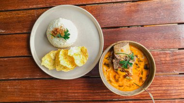 Tayland yemeği, körili pilav ve ahşap masada kızarmış yumurta.