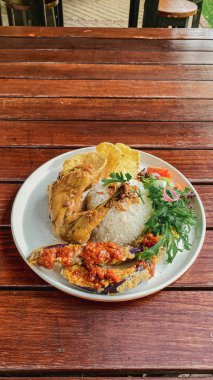 Tavuklu pilav ve sebzeli tahta masa.