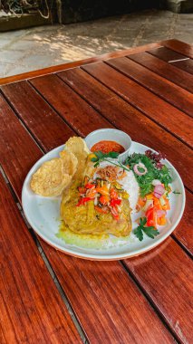 Kızarmış balık ve sebze, yanında yumurta ve pilav.