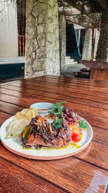 Tahta tabakla lezzetli bir yemeğin dikey yakın çekimi.