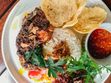 Kızarmış tavuk, pilav, sebze ve sos.