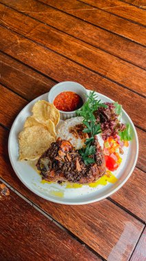 Ahşap masada ızgara domuz ve pilav..