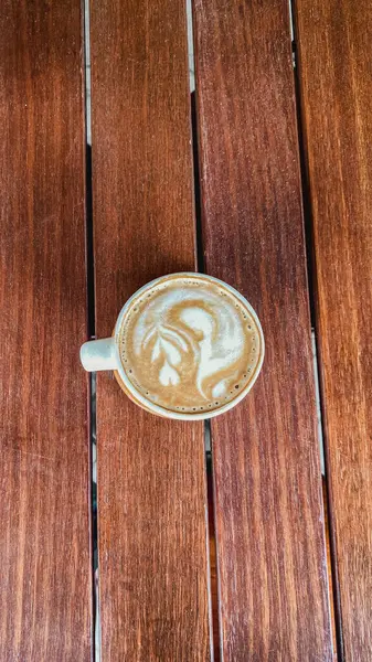 Sabahları tahta masada bir fincan kahve.
