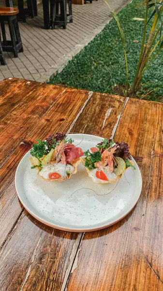 Tahta masada taze sebzeli, peynirli ve balıklı bir tabak..