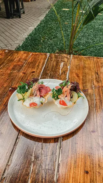 Tahta bir masada sebzeli ve etli bir tabak lezzetli sandviç.