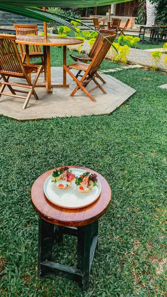 Masanın üzerinde ahşap bir sandalye olan bir tabağın yakın çekimi.