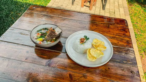 Kızarmış pilav, beyaz tabakta yumurta, ahşap kaplama, üst manzara.