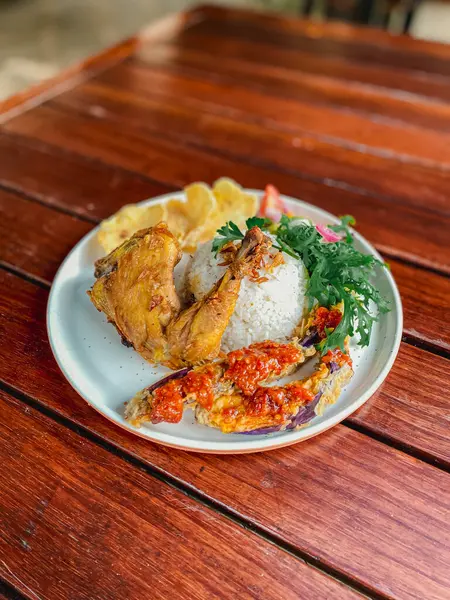 Tahta arka planda pilav ve sebzeli kızarmış tavuk.