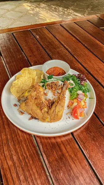 Sebzeli ve ahşap masadaki soslu kızarmış balık.