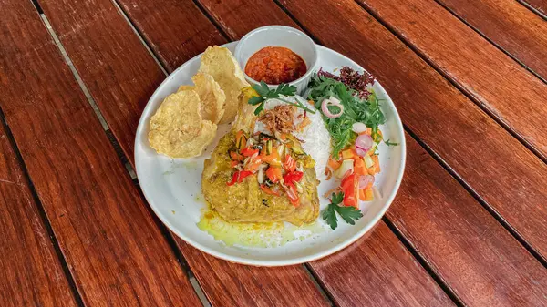 Tahta bir masada karides ve körili Tayland yemeği.