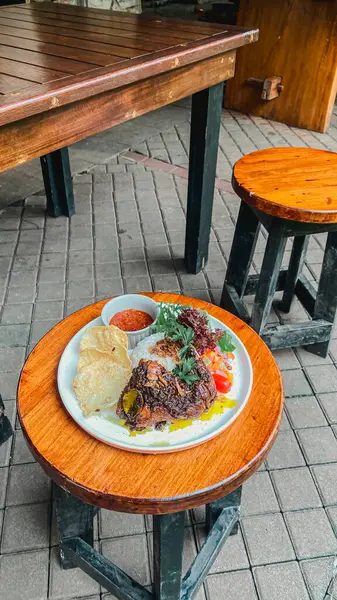 Kızarmış et, yumurta ve sebzeli bir tabak.