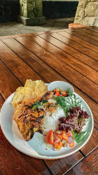 Tavuklu pilav ve sebze. Tahta bir tabakta.