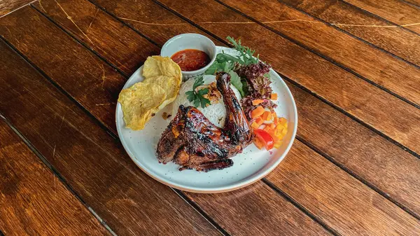 Kızarmış balık, sebzeli ve baharatlı beyaz tabakta.