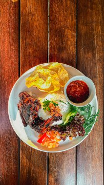 Kızarmış patates ve sebzeli kızarmış balık tabağı.