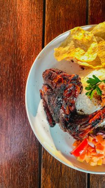 Baharatlı pirinçli kızarmış tavuk ve ahşap masada sebze, Asya yemekleri konsepti.