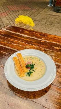 Ahşap arka planda tavuk ve sebzeli çorba.