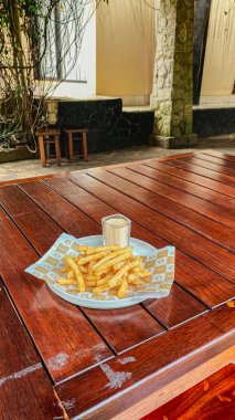 Restoranda bir masa, bir bardak bira ve masada bir şişe bira, ahşap bir tepsi, bir bardak bira.,