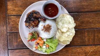 Tavuklu pilav, kızarmış yumurta ve beyaz tabakta salata.