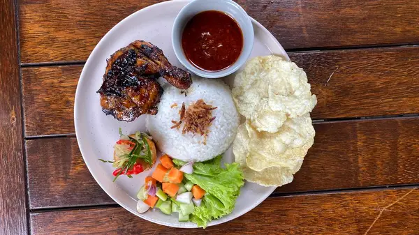 Tabakta servis edilen Endonezya yemeği ve kızarmış pirinç, tavuk, tavuk, tavuk ve sebze.