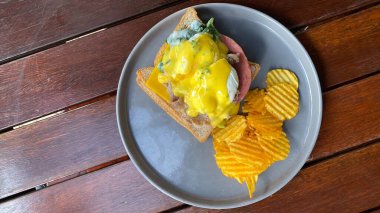 Tavuklu sandviç, patates, ahşap zemin üzerinde peynir.