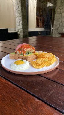 Ahşap bir masa ve beyaz bir tabakla yakın plan bir yemek fotoğrafı.